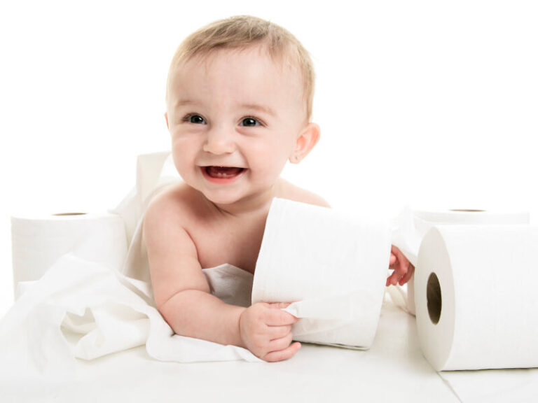 lachendes Baby spielt mit Klopapierrollen