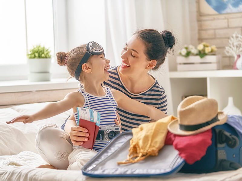 Mutter packt mit Tochter Koffer